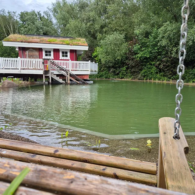 Blick auf den sanierten Naturbadteich mit der Teichsauna