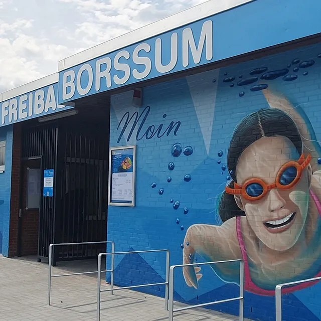 Eingang vom Freibad mit dem Schriftzug "Freibad Borssum" und dem Graffiti-Kunstwerk an der Wand